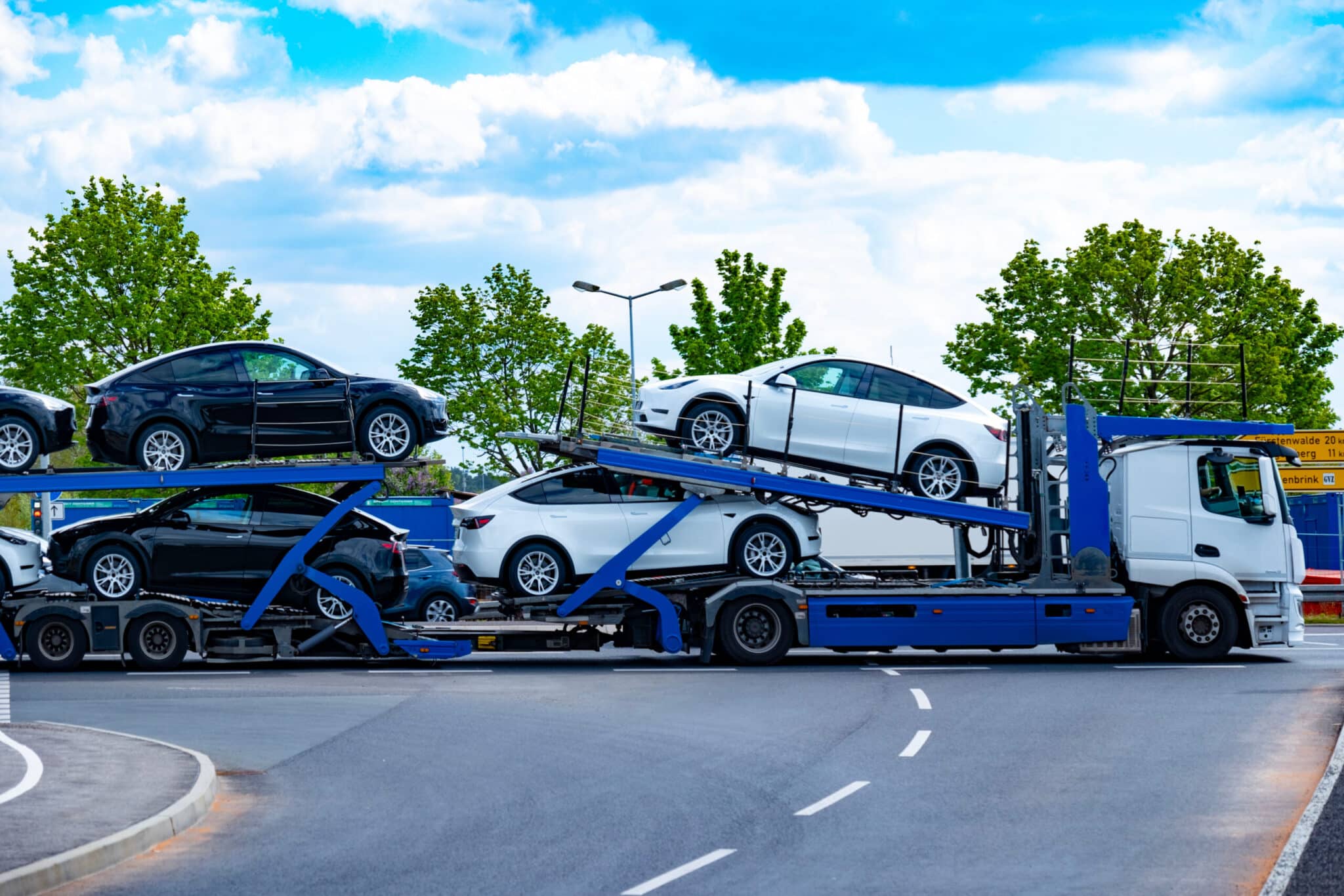 car transporter carrier transports new Tesla vehicles from Gigafactory Berlin-Brandenburg manufacturing plant along highway, Ev distribution, Berlin – April 26, 2024